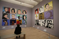 In this photo taken Wednesday, May 15, 2019, a woman views commissioned portraits from 1968-1987 at the exhibition, "Andy Warhol _ From A to B and Back Again" in San Francisco. A retrospective of Andy Warhol's work on display at the San Francisco Museum of Modern Art captures his use of artwork to give his subjects personas the way people do now using social media. (AP Photo/Eric Risberg)