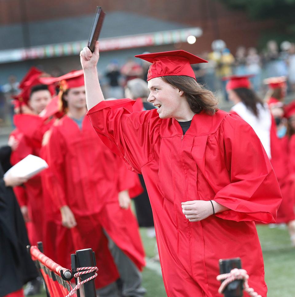 Sean McKeone waves his diploma at the North Quincy High graduation at Veterans Memorial Stadium on Monday, June 6, 2022.