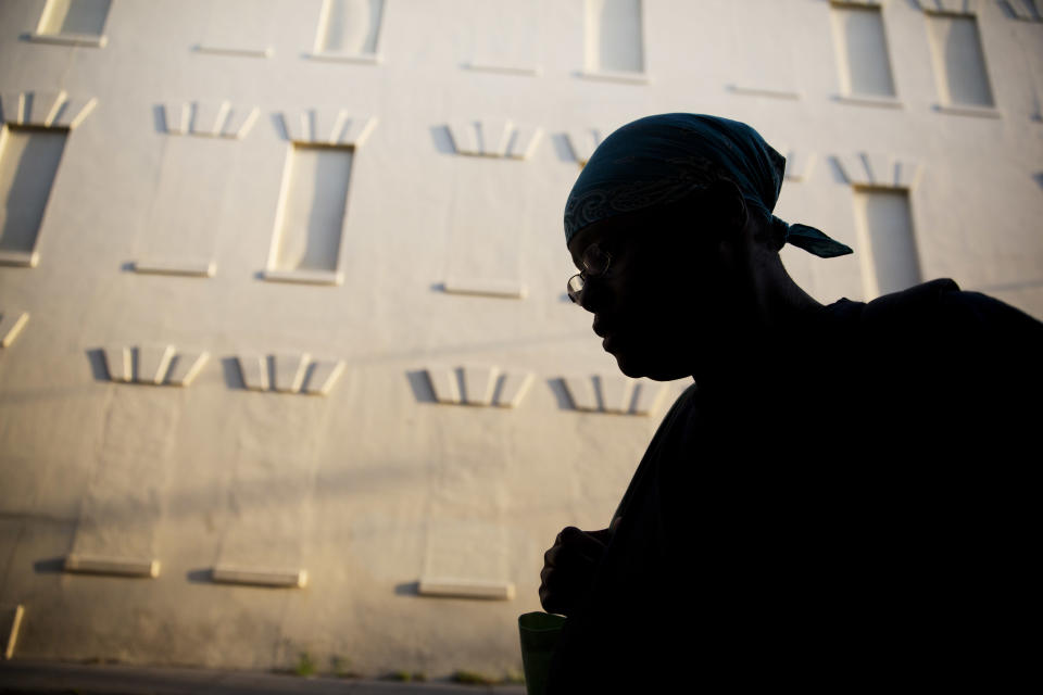 A woman walks to work on Thursday, June 18, 2015, a few blocks away from the Emanuel AME Church in Charleston, S.C.  A white man opened fire during a prayer meeting inside the historic black church Wednesday night, killing several people. The shooter remained at large Thursday morning and police released photographs from surveillance video of a suspect and a possible getaway vehicle. (AP Photo/David Goldman)