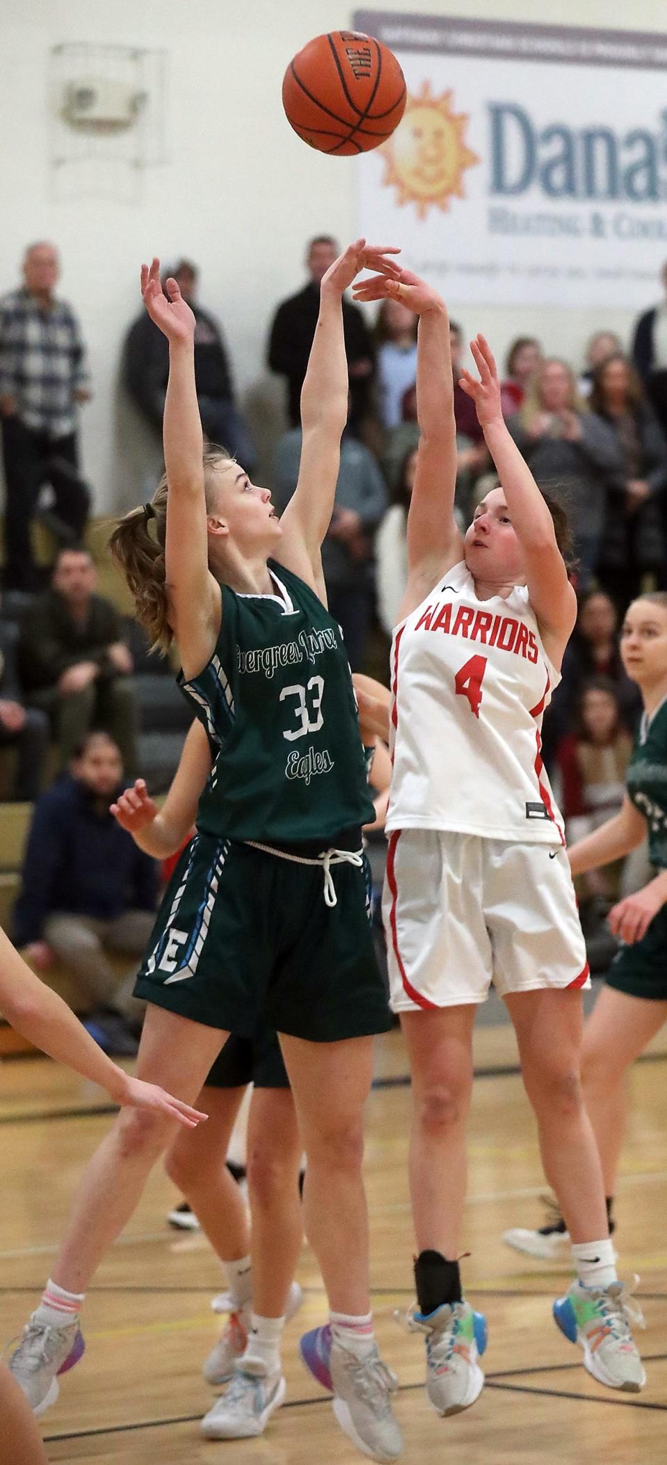 Crosspoint's Anna Kuske (4) takes a shot over Evergreen Lutheran's Hannah Rodmyre (33) during the Sea-Tac League 1B girls tournament on Feb. 8. Evergreen Lutheran won the game 29-27.