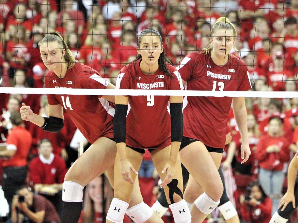 Wisconsin's Caroline Crawford (9), Anna Smrek (14) and Sarah Franklin (13) prepare to receive a serve during their match with Florida at the Kohl Center on Friday, Sept. 16. The match set a regular-season NCAA attendance record with 16,833 fans.