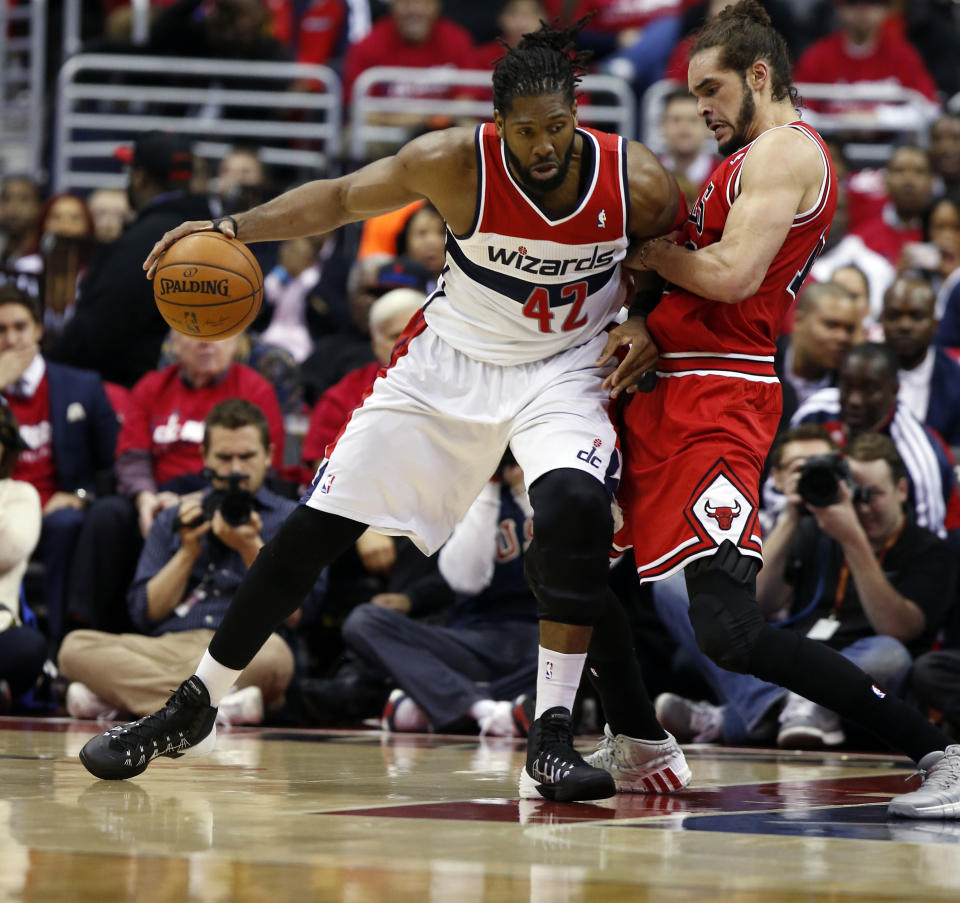 Washington Wizards forward Nene (42), from Brazil, drives against Chicago Bulls center Joakim Noah (13) in the first half of Game 3 of an opening-round NBA basketball playoff series on Friday, April 25, 2014, in Washington. (AP Photo/Alex Brandon)