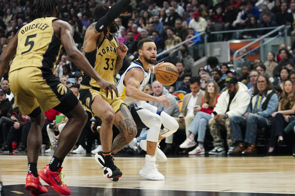 Golden State Warriors guard Stephen Curry (30) protects the ball from Toronto Raptors guard Gary Trent Jr. (33) during the first half of an NBA basketball game Friday, March 1, 2024, in Toronto. (Arlyn McAdorey/The Canadian Press via AP)