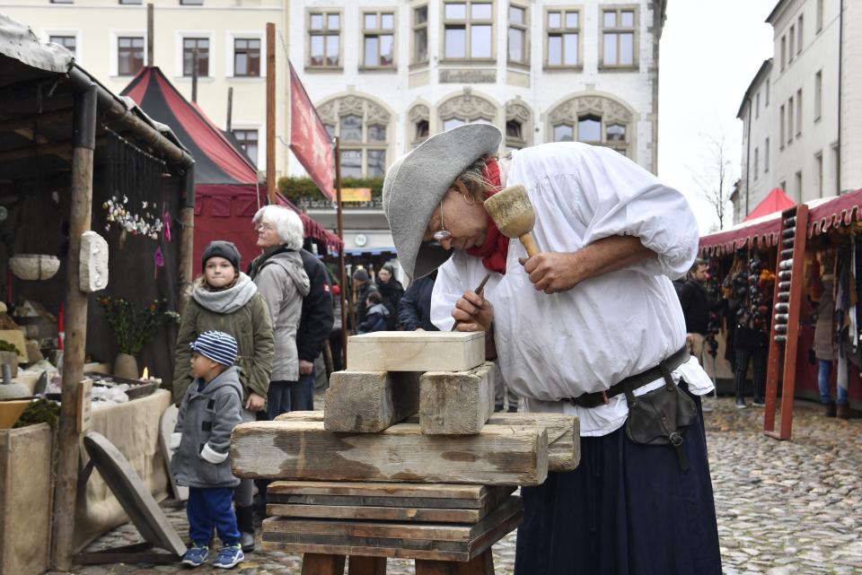 A traditional wood cutter engraves wood in the main square in Wittenberg, eastern Germany, where celebrations take place on the occasion of the 500th anniversary of the Reformation on October 31, 2017.&nbsp; (Photo: JOHN MACDOUGALL via Getty Images)