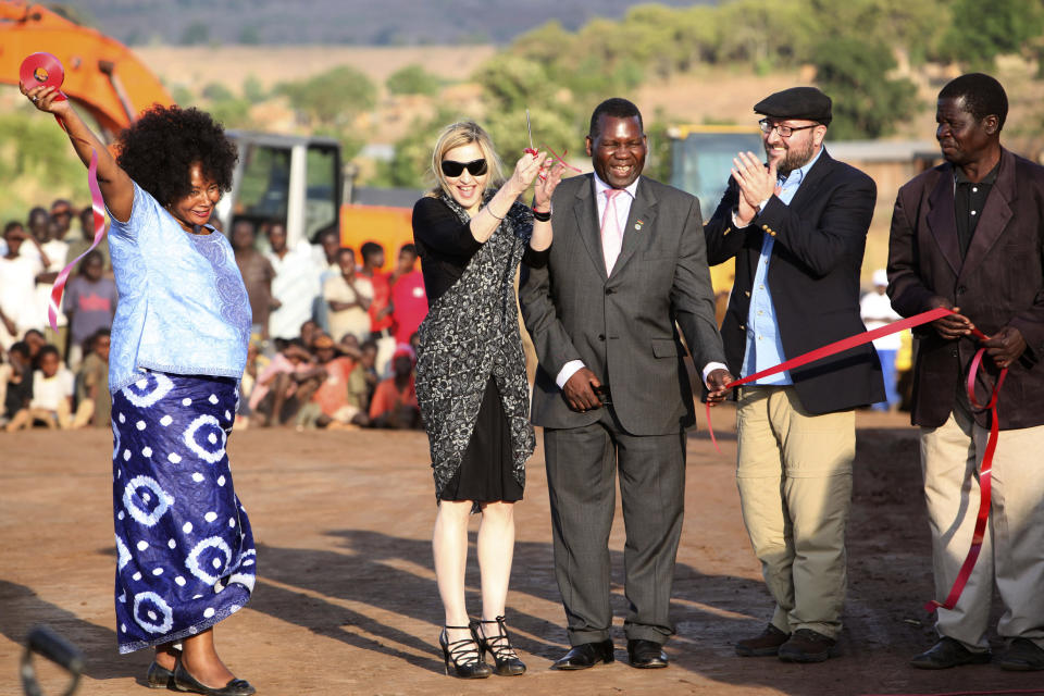 FILE - In this Oct. 26, 2009 file photo, US pop star Madonna, second from left, cuts the ribbon at the ground breaking ceremony for the Raising Malawi Academy for Girls in Lilongwe, Malawi. In 2009, George Chaponda, the education minister, helped Madonna break ground for a $15 million academy for girls. Early 2012 , Madonna's Raising Malawi foundation announced that instead of building the multimillion-dollar academy, it is providing $300,000 to the non-governmental organization buildOn, which has years of experience in Malawi, to develop 10 schools. They'll serve about 1,000 boys and girls in the southern African nation of 15 million that is among the poorest in the world. (AP Photo/file/Tsvangirayi Mukwazhi, File)