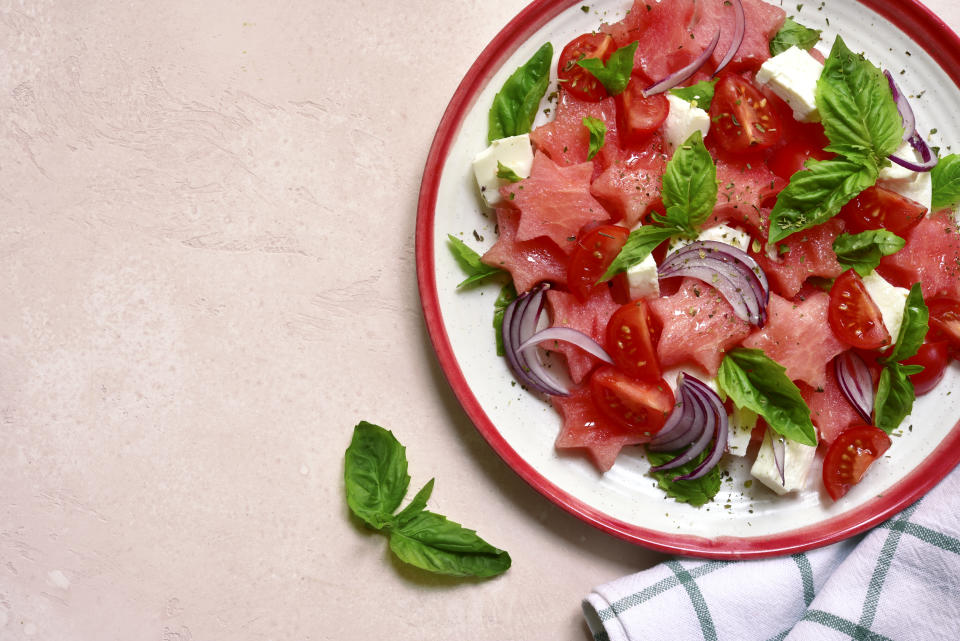 Watermelon salad with tomato, feta cheese, red onion and basil. Yum. Photo: Getty