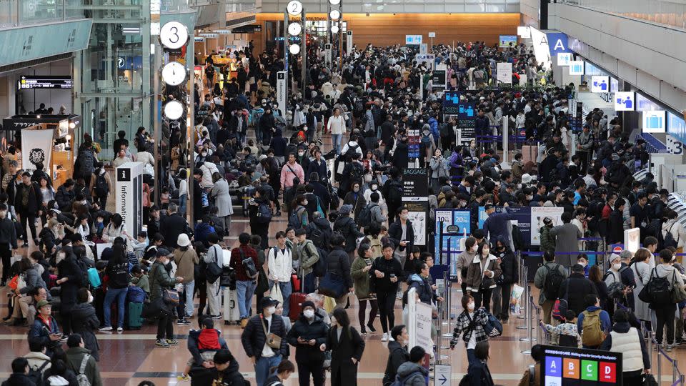 Travelers crowd the check-in area at terminal 2 at Tokyo's Haneda Airport on January 3, 2024. - Stringer/JIJI Press/AFP/Getty Images