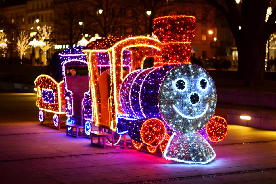 Warsaw, Poland - December 6th, 2015: Christmas lights on the locomotive with carriages on the Warsaw street at night. The streets in a city is decorated by many interesting Christmas ornaments and lights in december. The children really like especially the Christmas locomotive.