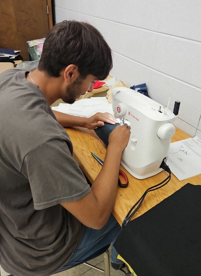 Jared Varela works on clothing for the adaptive fashion show using a sewing machine that was provided through the Gaston Arts Council Grassroots Grant.