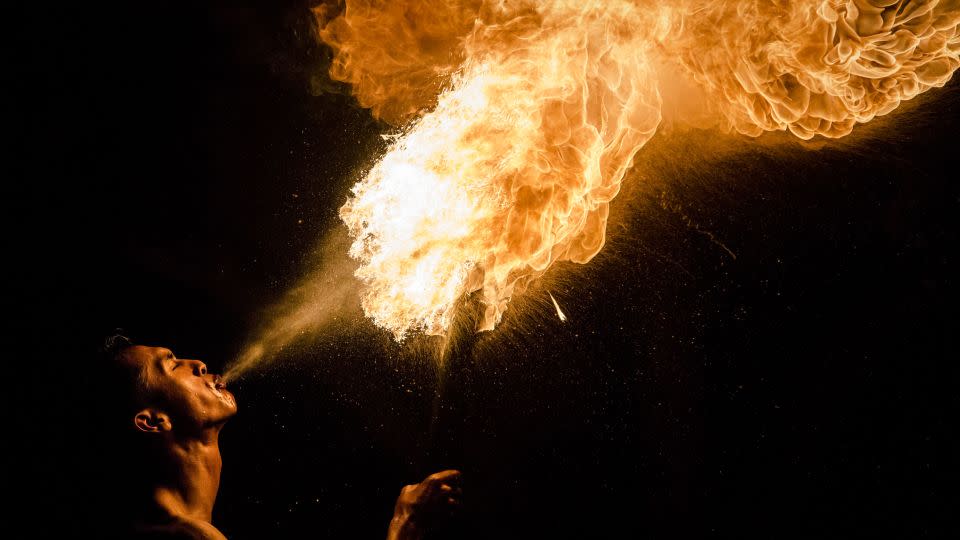 A Muslim man breathes fire during a game of fire football, known as "bola api." - Ulet Ifansasti/Getty Images