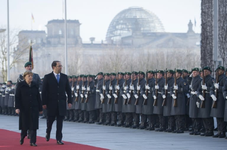 German Chancellor Angela Merkel and Tunisian Prime Minister Youssef Chahed review troops at the Chancellery in Berlin on February 14, 2017