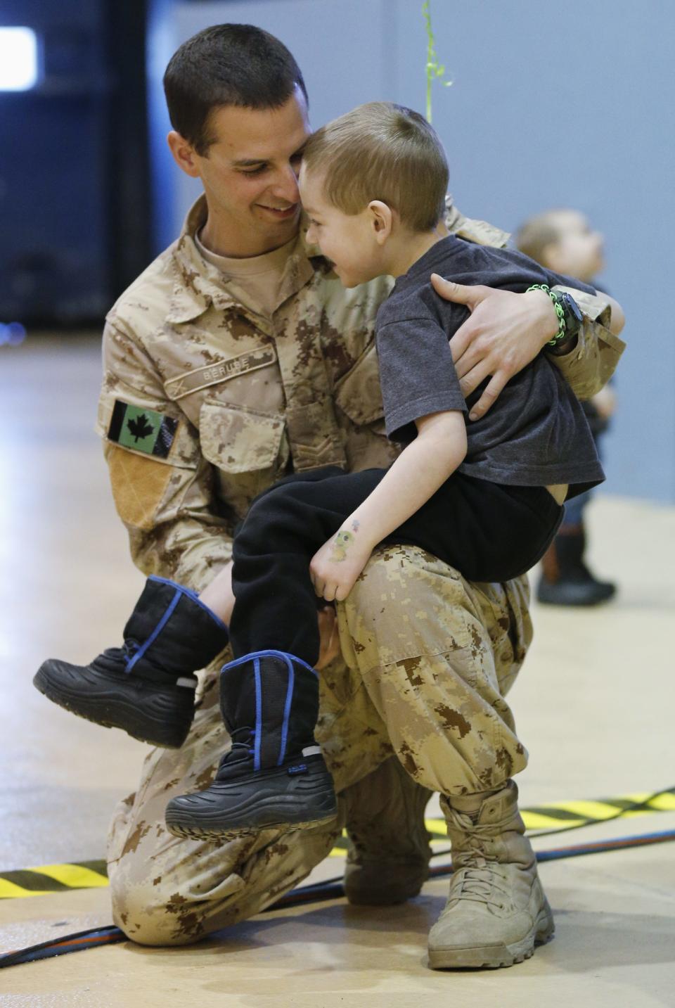 Corporal Danny Berube holds his son Jaxx after arriving from Afghanistan, in Ottawa