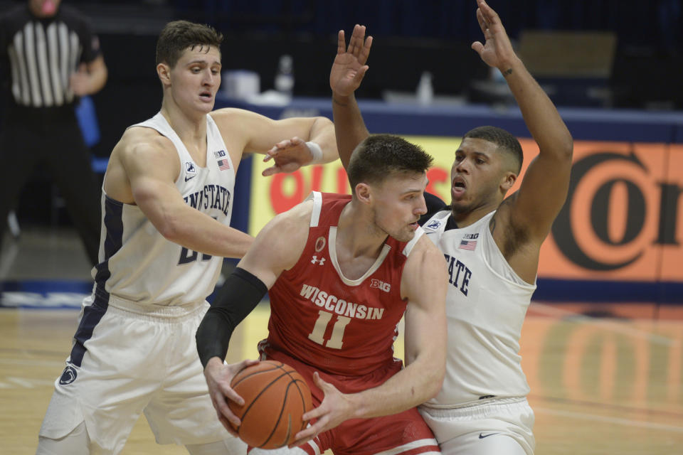 Penn State's John Harrar, left, and Myles Dread, right, pressure Wisconsin's Micah Potter, center, in the second half of an NCAA college basketball game, Saturday, Jan. 30, 2021, in State College, Pa. (AP Photo/Gary M. Baranec)