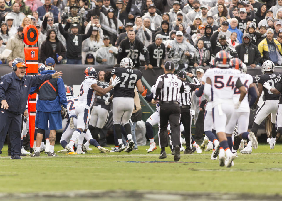 <p>Oakland Raiders wide receiver Michael Crabtree (15) and Denver Broncos cornerback Aqib Talib (21) fight on the sidelines as both teams run to the fight during the first quarter at Oakland Coliseum. Mandatory Credit: Neville E. Guard-USA TODAY Sports </p>