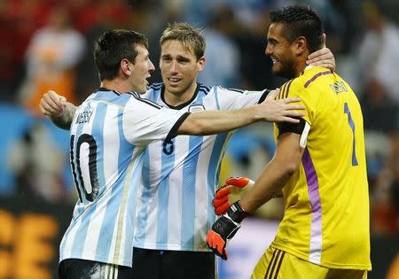 (L-R) Argentina's Lionel Messi, Lucas Biglia and goalkeeper Sergio Romero celebrate after winning their 2014 World Cup semi-finals against Netherlands at the Corinthians arena in Sao Paulo July 9, 2014. REUTERS/Dominic Ebenbichler