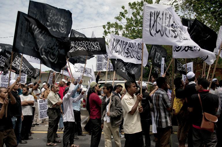 Malaysian Muslim activists in Kuala Lumpur on February 14, 2014 carry flags during a peaceful protest against the persecution of Rohingya Muslims in Myanmar