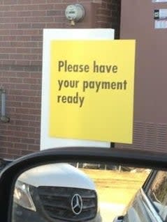 Sign reading "Please have your payment ready" at the drive-thru
