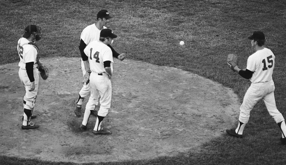 Red Wings manager Joe Altobelli (26) top center, takes the ball from pitcher Dave Leonhard (14) and tosses it to his reliever Ed Maras (15), right, as catcher Johnny Oates (12) looks on during the pitching change during the Wings loss to Louisville, 10-0, June 1, 1971 at Frontier Field. 