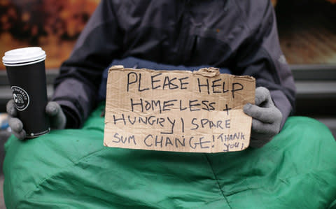 A homeless man holding a sign reading 'Please help, homeless and hungry' in Victoria, London - Credit: Yui Mok/PA 