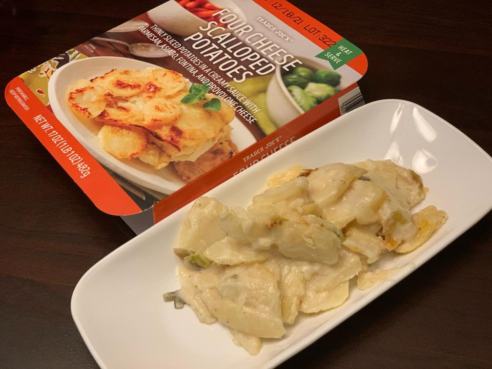 red package of trader joe's scalloped potatoes next to cooked version on a plate