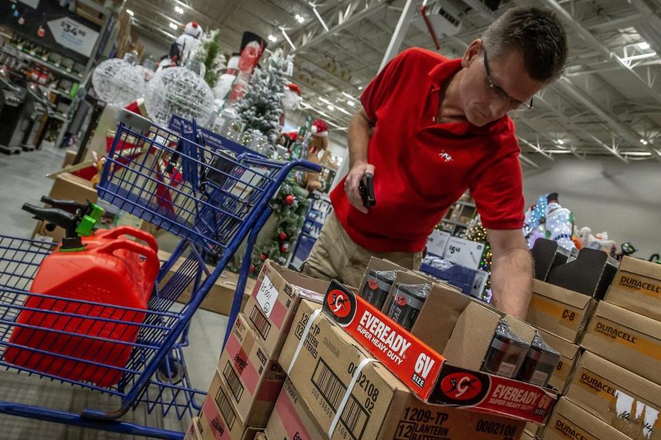 Damir Kukec, West Palm Beach, selects batteries from a display offering at Lowe's Home Improvement store in West Palm Beach, Fla., on September 25, 2022. Kukec is gathering backups of storm supplies, he said.