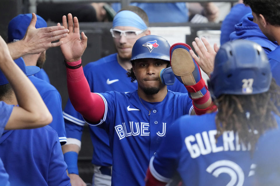 Toronto Blue Jays' Santiago Espinal, center, is congratulated after scoring on a single by Bo Bichette against the Chicago White Sox during the 11th inning in the first baseball game of a doubleheader Thursday, July 6, 2023, in Chicago. The Blue Jays won 6-2. (AP Photo/Nam Y. Huh)