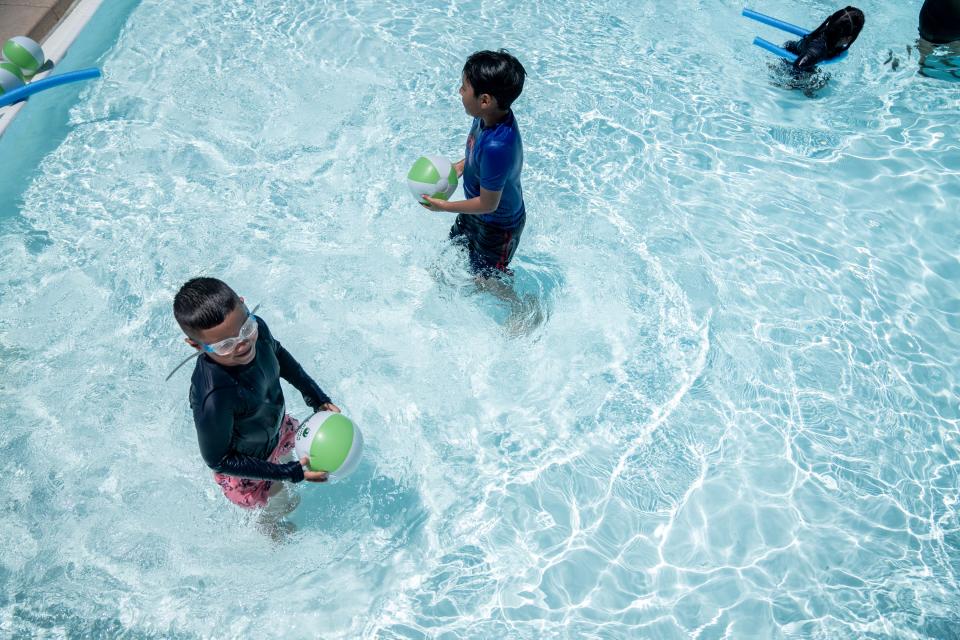 Israel Cruz, 6 (left), swims at the Falcon Pool in Phoenix on July 25, 2023.