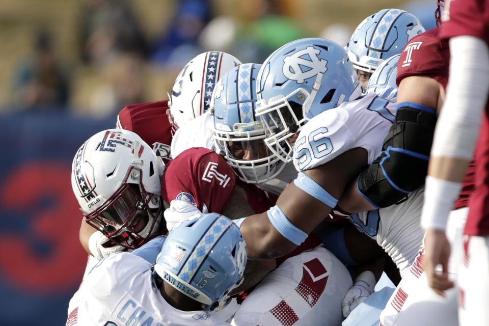 Temple running back Re'Mahn Davis, left, is grabbed by North Carolina defenders during the second half of the Military Bowl NCAA college football game, Friday, Dec. 27, 2019, in Annapolis, Md. (AP Photo/Julio Cortez)