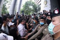 Pro-democracy protesters stand outside the criminal court building demanding a representative be allowed inside where two leaders are still detained at the criminal court in Bangkok