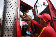 In this Sept. 3, 2018 photo, Venezuelan Sandra Cadiz and her 10-year-old daughter Angelis, thank gas station worker Manuel Velasquez after he helped them get a ride in the cabin of a truck in Peroles, Colombia, on their journey to Peru. Whenever the two got a ride in the cabin of a truck, Cadiz made a point of seating her daughter closest to the passenger door, putting herself as a protective layer between the driver and her daughter. (AP Photo/Ariana Cubillos)