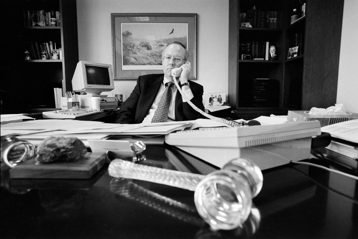 Special Prosecutor Ken Starr on the phone in his office, his desk covered with papers.