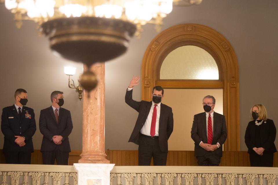 Accompanied by members of the executive cabinet, Kansas Republican Attorney General Derek Schmidt waves his hand after being acknowledged by Gov. Laura Kelly during her State of the State address Tuesday evening.