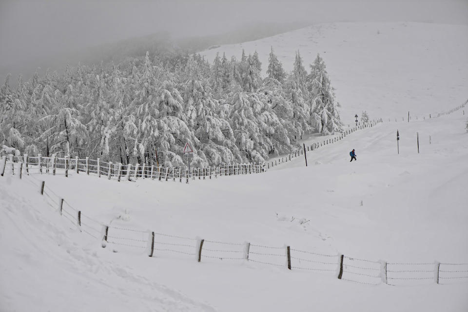 A person walks through a snowy landscape near the French border in Ibaneta, northern Spain, Monday, Jan. 8, 2024. (AP Photo/Alvaro Barrientos)
