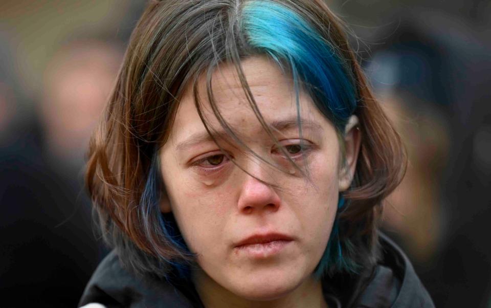 A woman cries outside the headquarters of Charles University for the victims of mass shooting