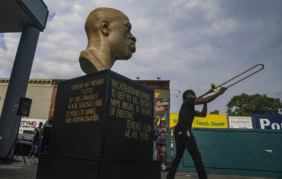 FILE - Jonte "Jonoel" Lancaster plays a trombone during a celebration for the refurbished George Floyd statue, after it was vandalized following its Juneteenth installation, Thursday, July 22, 2021 in the Flatbush section of Brooklyn borough of New York. (AP Photo/Bebeto Matthews, File)