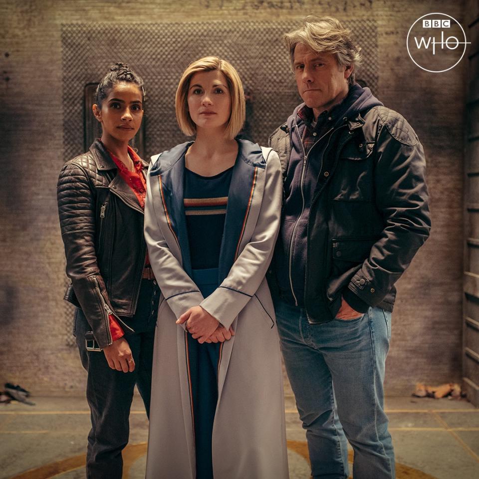 Yaz (Mandip Gill) wears a leather jacket, the Doctor (Jodie Whittaker) wears her usual costume, and Dan (John Bishop) wears a jacket and jeans, in a promo image for the new series of Doctor Who.