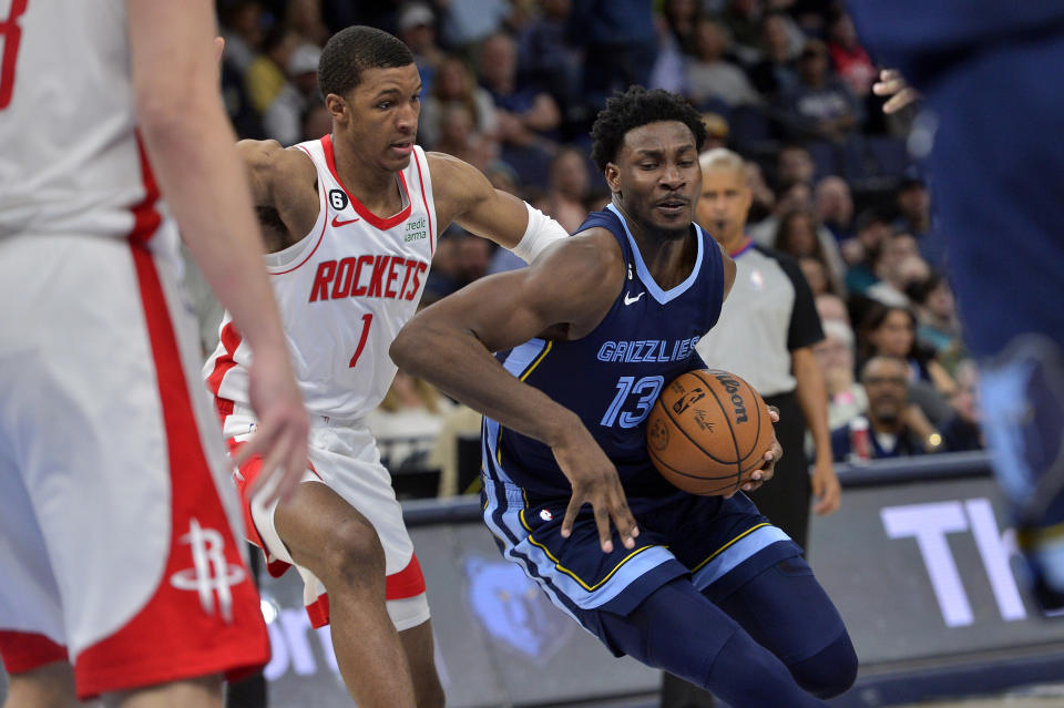 Memphis Grizzlies forward Jaren Jackson Jr. (13) handles the ball against Houston Rockets forward Jabari Smith Jr. (1) in the second half of an NBA basketball game Wednesday, March 22, 2023, in Memphis, Tenn. (AP Photo/Brandon Dill)