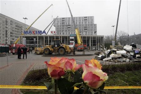 Flowers are placed near a collapsed supermarket in capital Riga November 22, 2013. REUTERS/Ints Kalnins