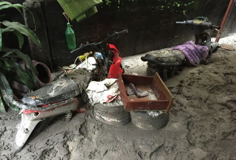Motorcycles seen buried in think mud in a community located next to the Mong Duong coal mine on August 1, 2015 following heavy rains in the northern coastal province of Quang Ninh