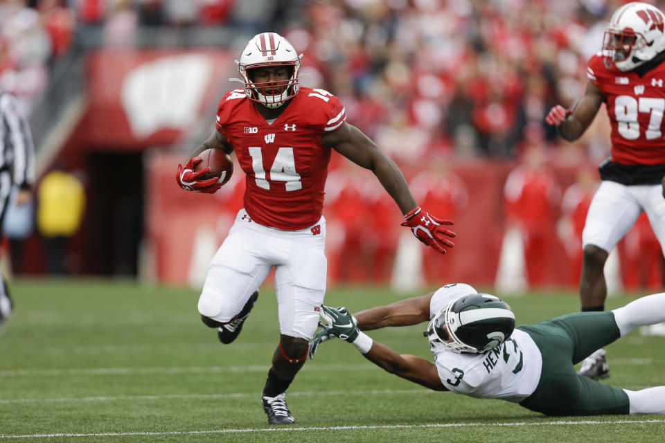 FILE - In this Oct. 12, 2019, file photo, Wisconsin running back Nakia Watson (14) runs past Michigan State safety Xavier Henderson (3) during the first half of an NCAA college football game, in Madison, Wis. Even after beating a Wisconsin team that was favored by 30 ½ points last year, Illinois heads into Madison as a 19 ½-point underdog as the two West Division rivals prepare to open the pandemic-delayed Big Ten season Friday night. “Illinois definitely deserves a butt-whooping from last year,” Wisconsin running back Nakia Watson said earlier this month. (AP Photo/Andy Manis, File)