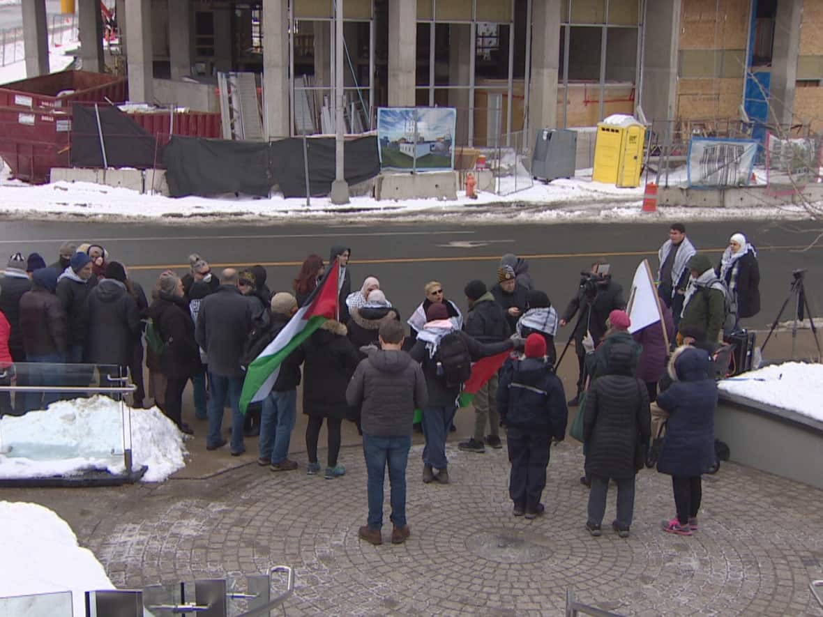 The protesters gathered outside the Department of Education building on Brunswick Street in Halifax Monday after some students were told to remove traditional Palestinian scarves during culture day at Park West School last week.  (Eric Wooliscroft/CBC - image credit)