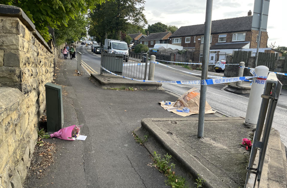 Police cordon and a floral tribute near to the scene in Woodhouse Hill, Huddersfield, where a 15-year-old boy was stabbed and later died in hospital on Wednesday. Picture date: Thursday September 22, 2022.