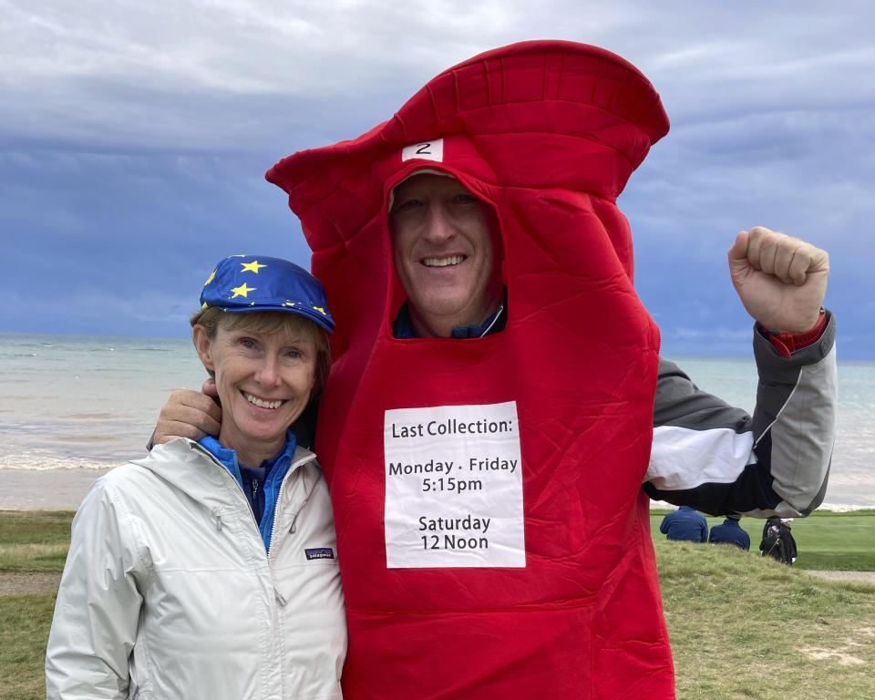 Gavin Kidd, right, and his wife, Lesley Kidd, left, cheer for Europe during a Ryder Cup golf practice at Whistling Straits outside Sheboygan, Wis., Thursday, Sept. 23, 2021. The Kidds live in Houston, but Gavin is originally from Liverpool, England, and Lesley is from Scotland. Gavin is wearing a mailbox costume to honor European golfer Ian Poulter, who has been nicknamed “The Postman” because he delivers so consistently in Ryder Cup competition. (AP Photo/Steve Megargee)