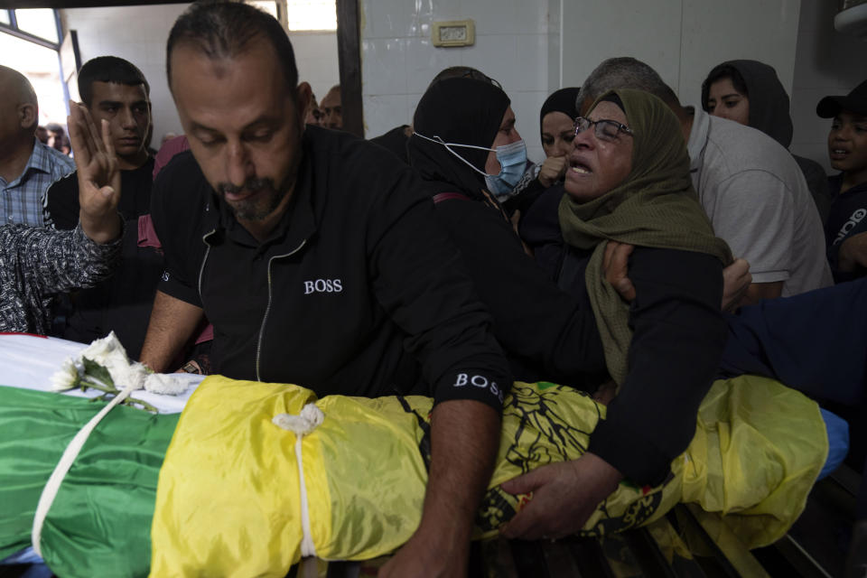 Mourners cry during the funeral of Mohammed Fadi Nuri, 16, in the West Bank city of Ramallah, Thursday, Oct. 20, 2022. Nuri succumbed to his wounds sustained during clashes with Israeli troops late last month, Palestinian health officials said. Meanwhile, the Palestinians launched a general strike throughout the West Bank and east Jerusalem in response to the death of a suspected Palestinian attacker. (AP Photo/Nasser Nasser)