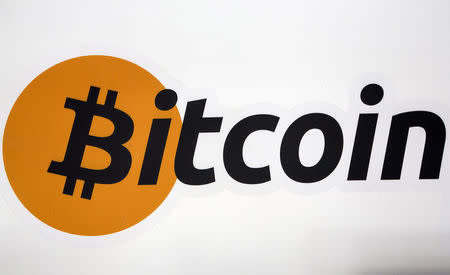 FILE PHOTO - A Bitcoin logo is displayed at the Bitcoin Center New York City in New York's financial district in NY, U.S. on July 28, 2015. REUTERS/Brendan McDermid/File Photo