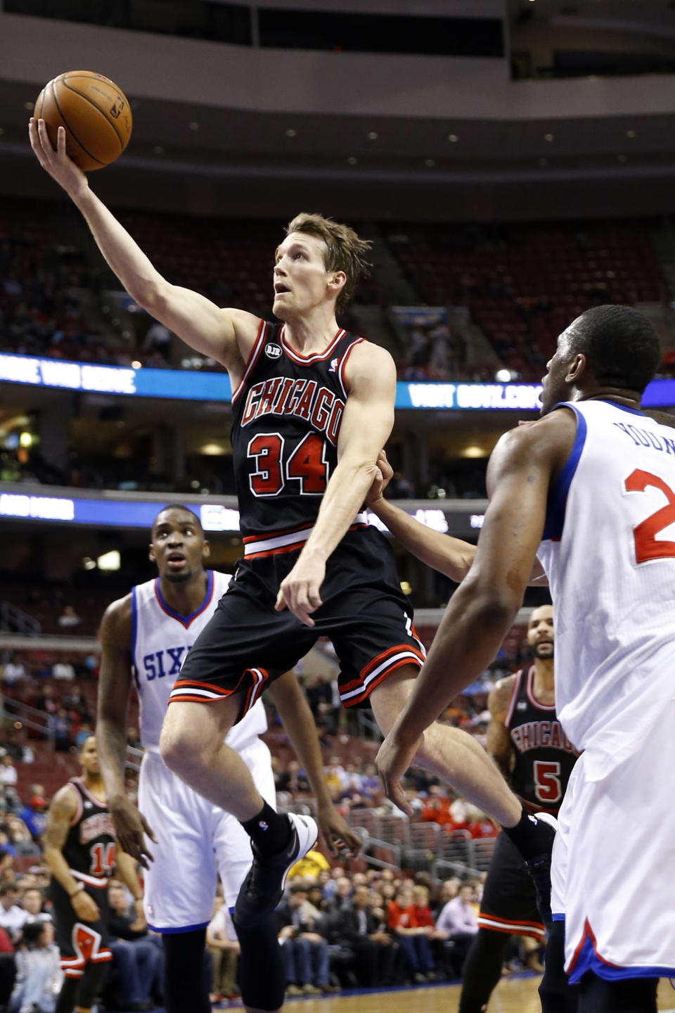 Chicago Bulls' Mike Dunleavy, center, goes up for a shot between Philadelphia 76ers' Jarvis Varnado, left, and Thaddeus Young during the first half of an NBA basketball game, Wednesday, March 19, 2014, in Philadelphia. (AP Photo/Matt Slocum)