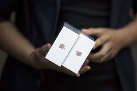 One of the first customers holds his phones as the Apple iPhone 6s and 6s Plus go on sale at an Apple Store in Beijing, in this September 25, 2015 file photo. REUTERS/Damir Sagolj/Files