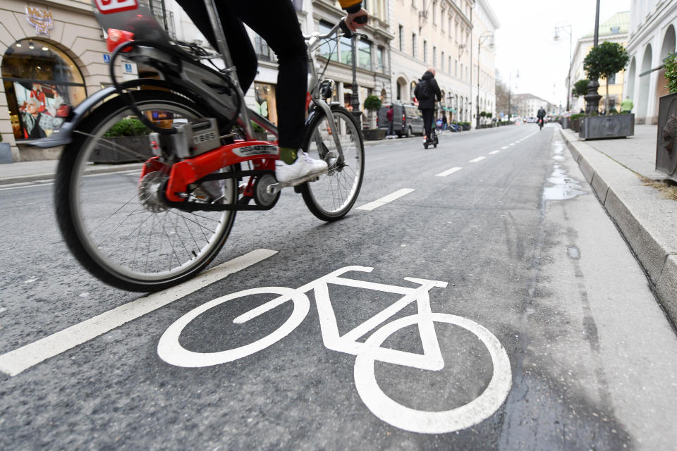 08 January 2020, Bavaria, Munich: A cyclist and a scooter driver pass the markings for a cycle path on the Brienner Straße. Until recently the Brienner Straße was passable for cars in both directions, there was no cycle path. In the future, there will be less space for cars in Munich's city centre. Cyclists and pedestrians should benefit. First measures have already been implemented.     (to dpa "Operation at the heart: Munich gets tips for car-free old town " from 08.01.2020) Photo: Tobias Hase/dpa (Photo by Tobias Hase/picture alliance via Getty Images)