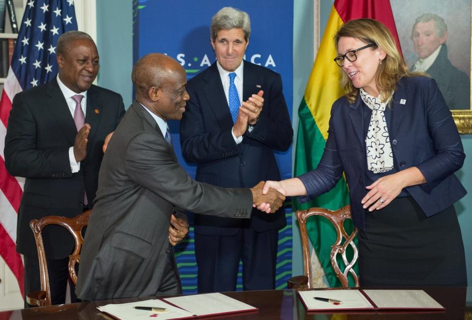 Dana Hyde, CEO of the Millennium Challenge Corporation, shakes hands with Ghana finance minister Seth Terkper as Ghana President John Dramani Mahama, left, and US Secretary of State John Kerry look on, during the signing the Ghana Compact at the State Department on 6 August 6, 2014 (AFP via Getty Images)