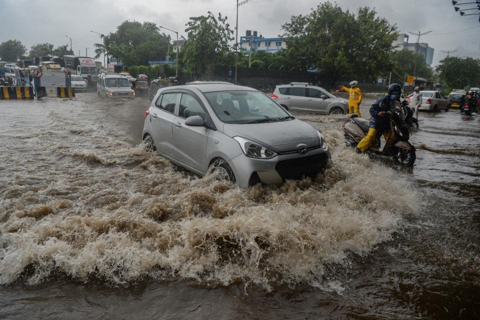 Motorists drive through a flooded road during a heavy monsoon rain in Mumbai on August 4, 2020. (Photo by INDRANIL MUKHERJEE/AFP via Getty Images)